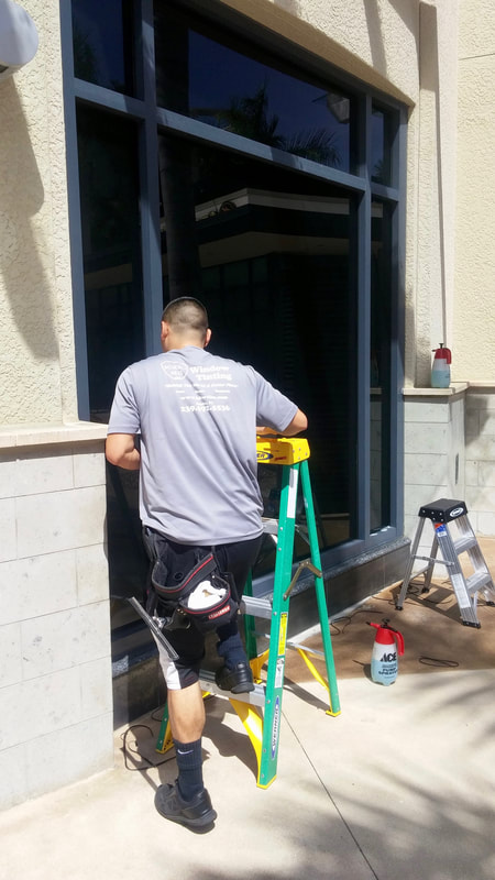 Technician installs privacy window film at Cavo Lounge in Naples, FL.