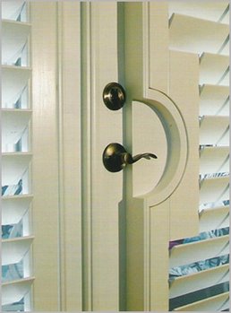 Plantation shutters installed around doorknob of french doors